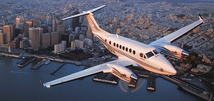 Avião de pequeno porte sobrevoando uma cidade.